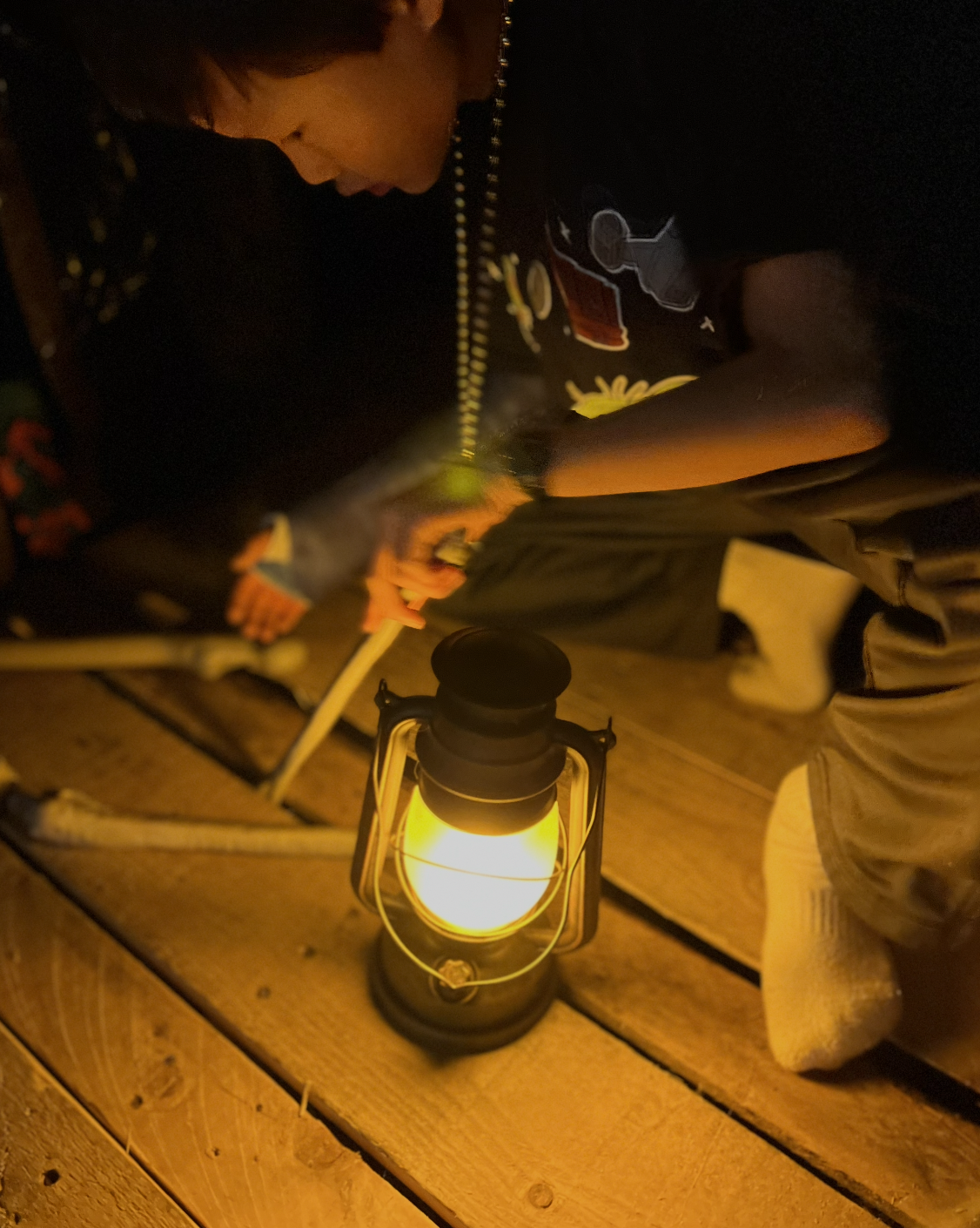 A student searches for clues by lantern light inside the WSA escape room
